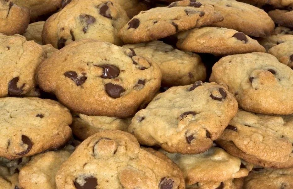 Pile of golden-brown chocolate chip cookies with visible chocolate chunks.