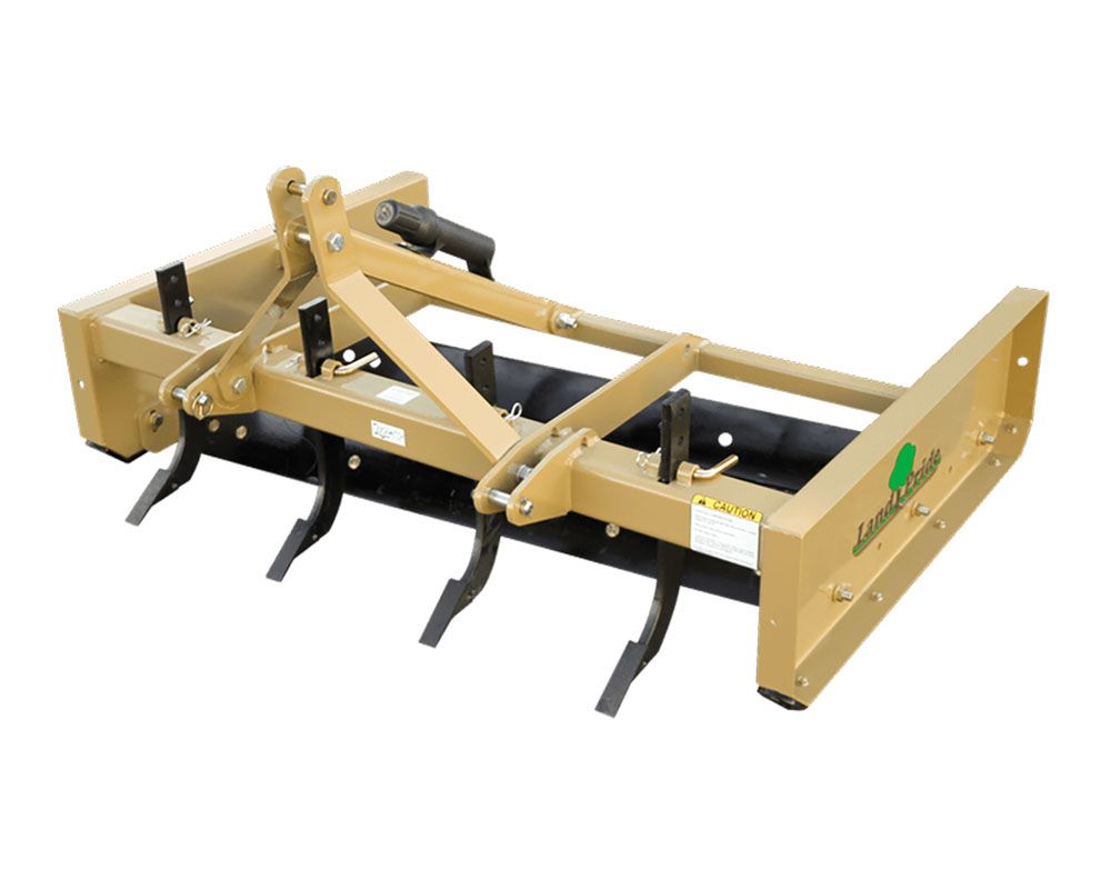 Tan Land Shark box blade with ripper teeth, designed for agricultural use, on a white background.