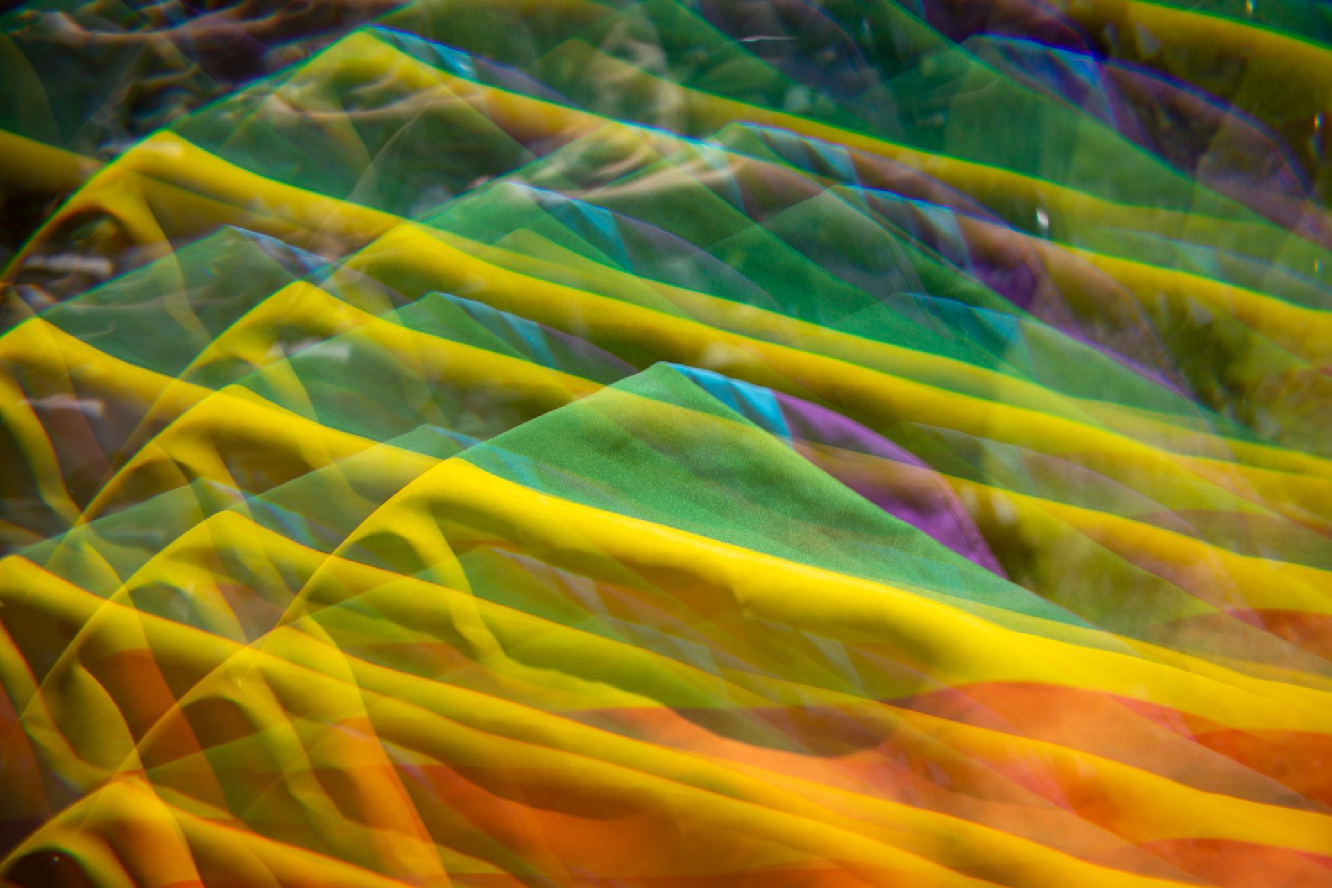 Abstract layers of a Pride Flag, overlapping with a blurred effect.