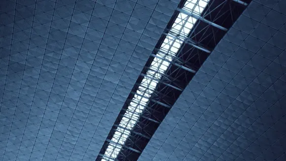 Looking up at the ceiling of a building with a blue sky in the background