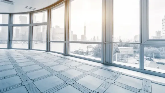 An empty room with a lot of windows and a view of the city.