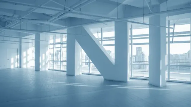 A man is standing on a ladder in a room under construction.