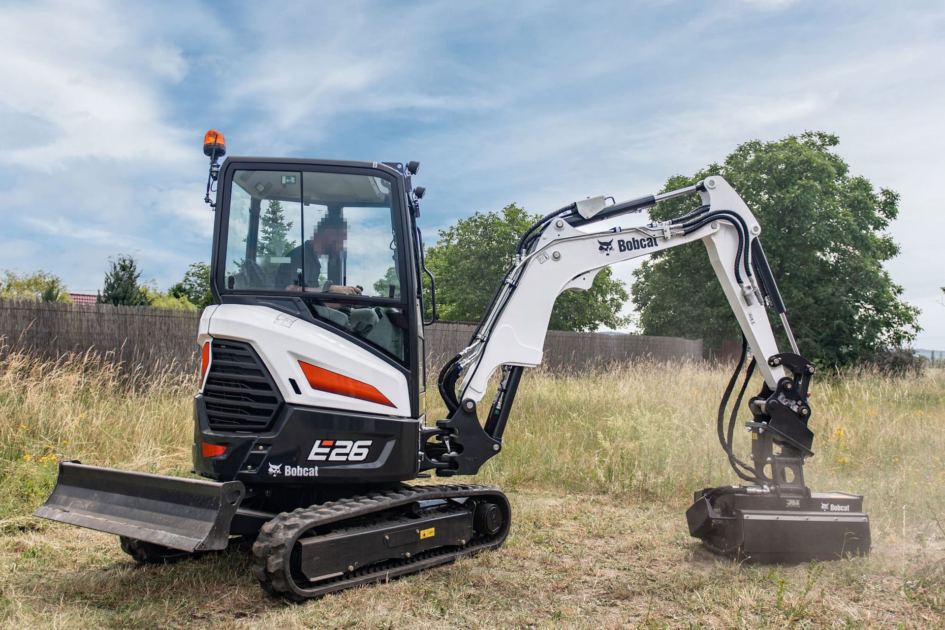 Miniescavatore Bobcat al lavoro in un campo.