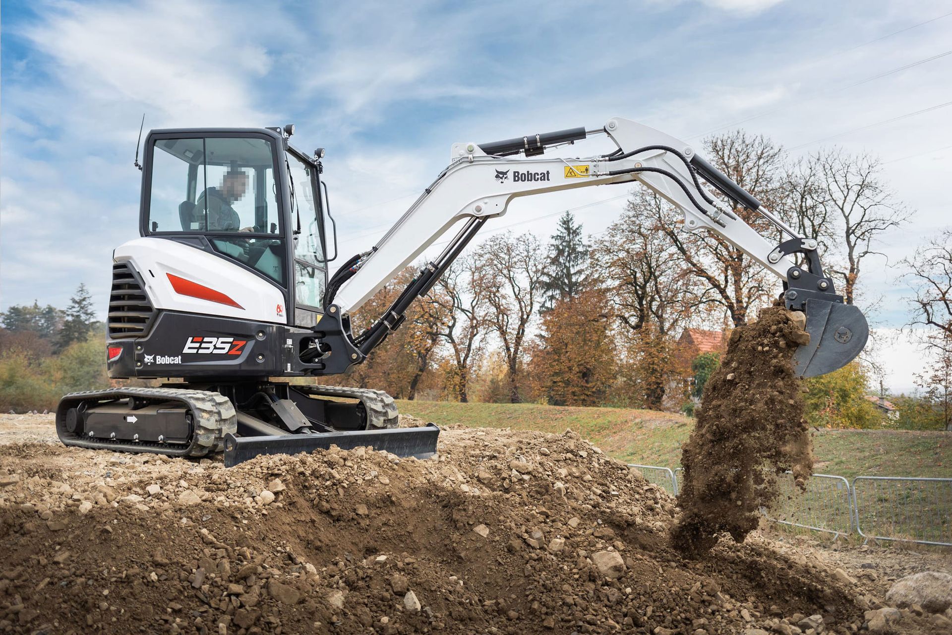 Miniescavatore Bobcat al lavoro in un campo.