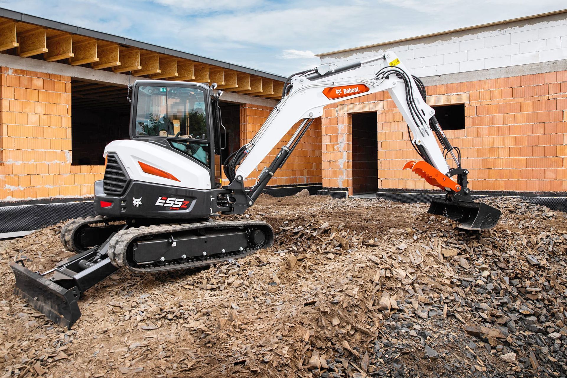 Escavatore Bobcat in un cantiere edile, che raccoglie terra. 