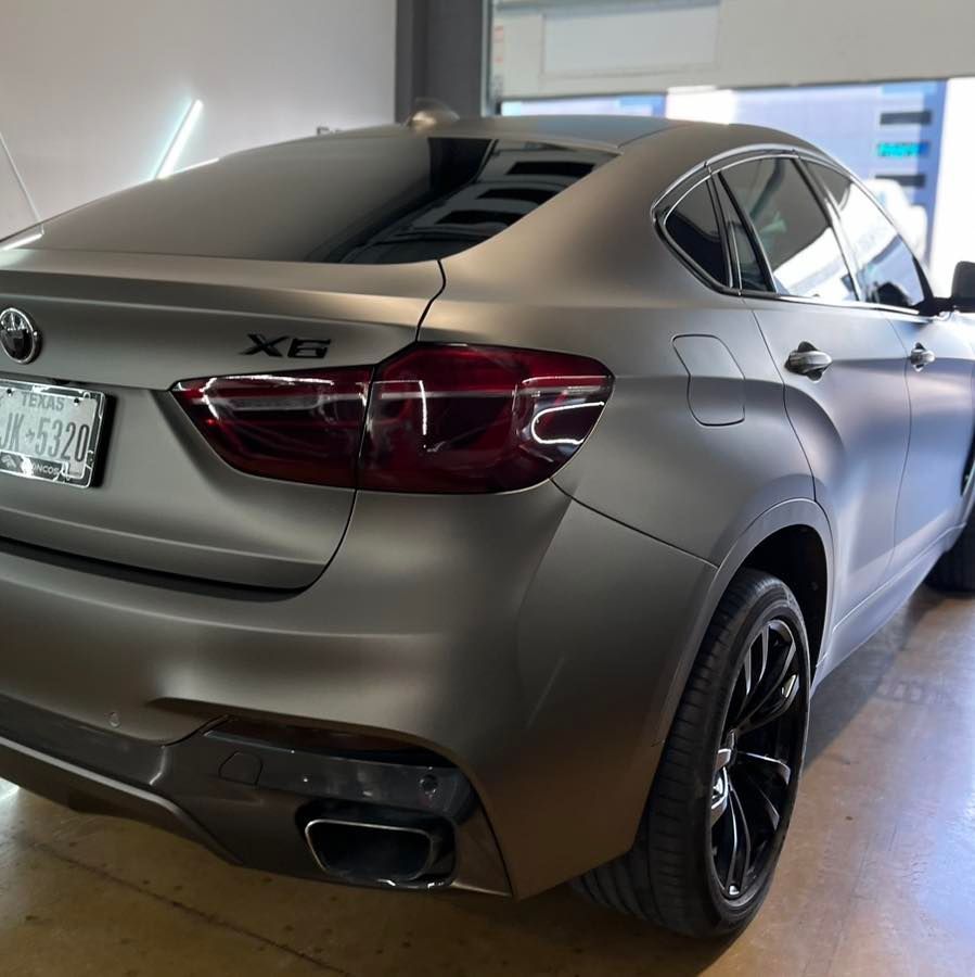 A silver bmw x6 is parked in a garage
