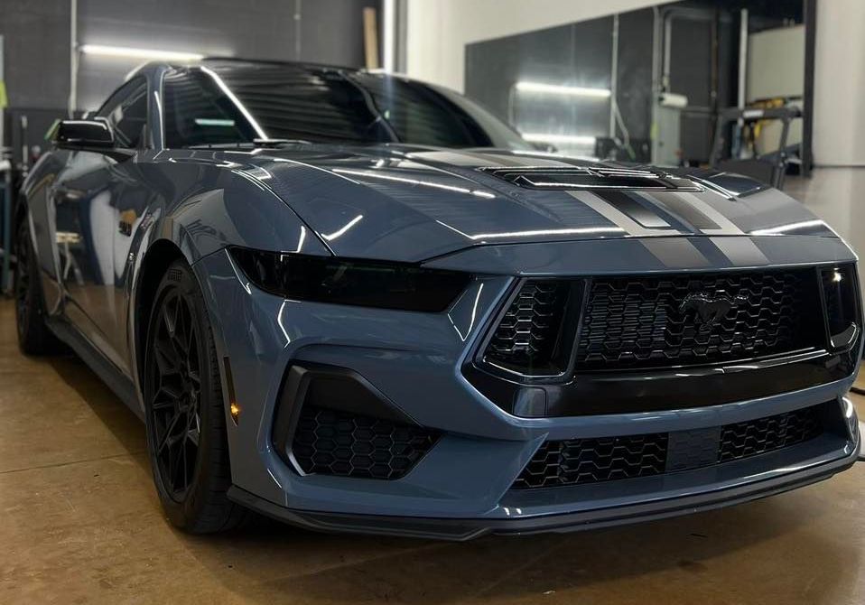 A gray ford mustang is parked in a garage.