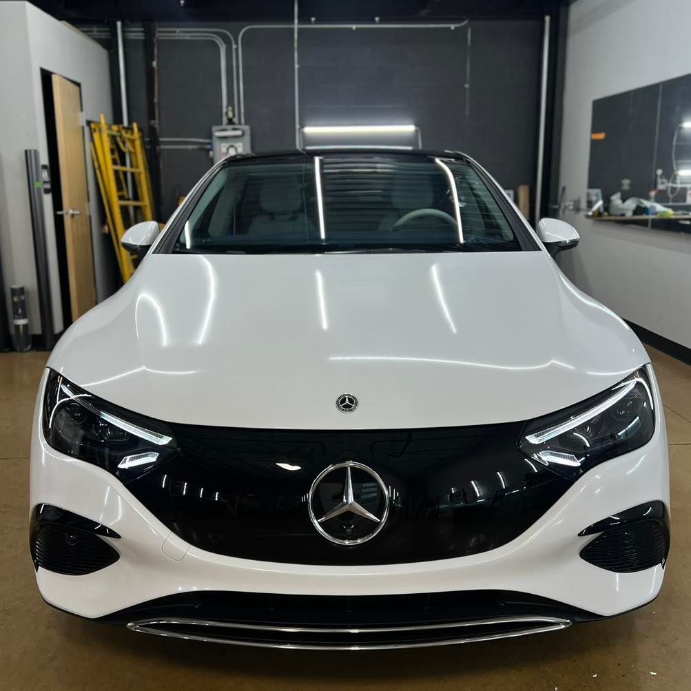 A white mercedes is parked in a garage
