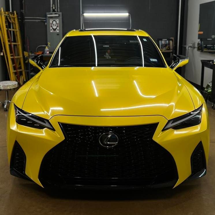 A yellow lexus car is parked in a garage