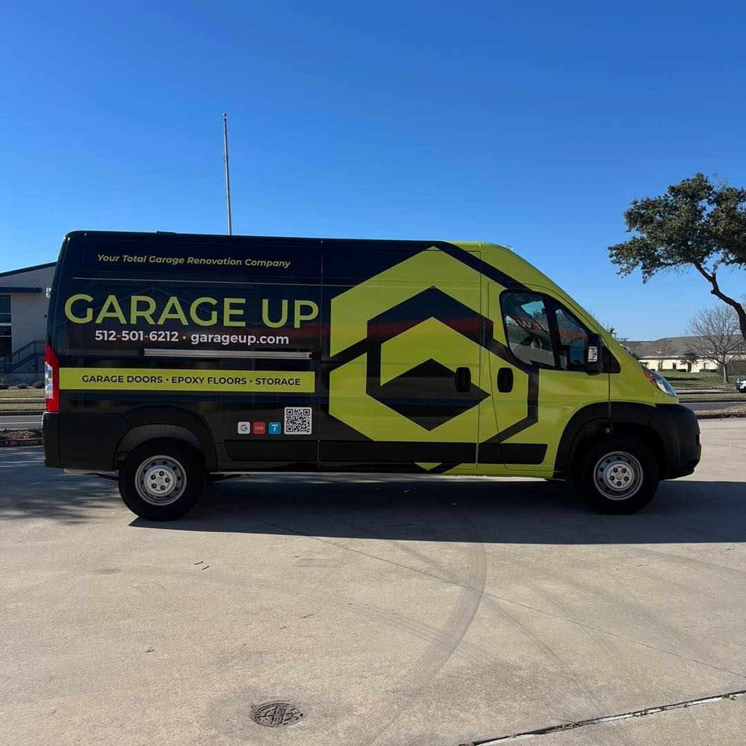 A yellow garage up van is parked on the side of the road