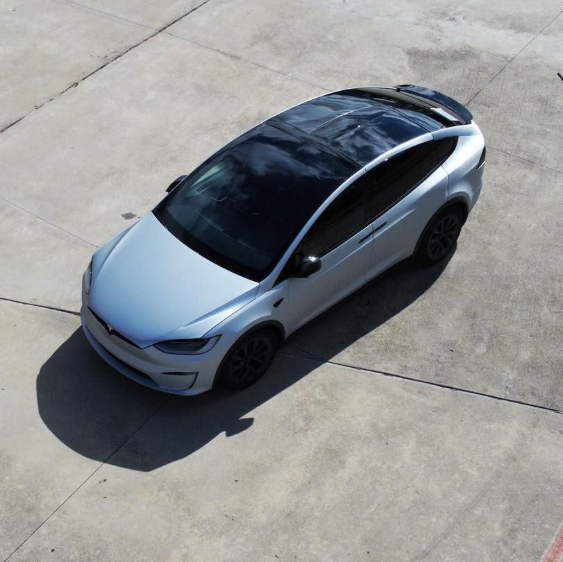 A tesla model x is parked on a concrete surface