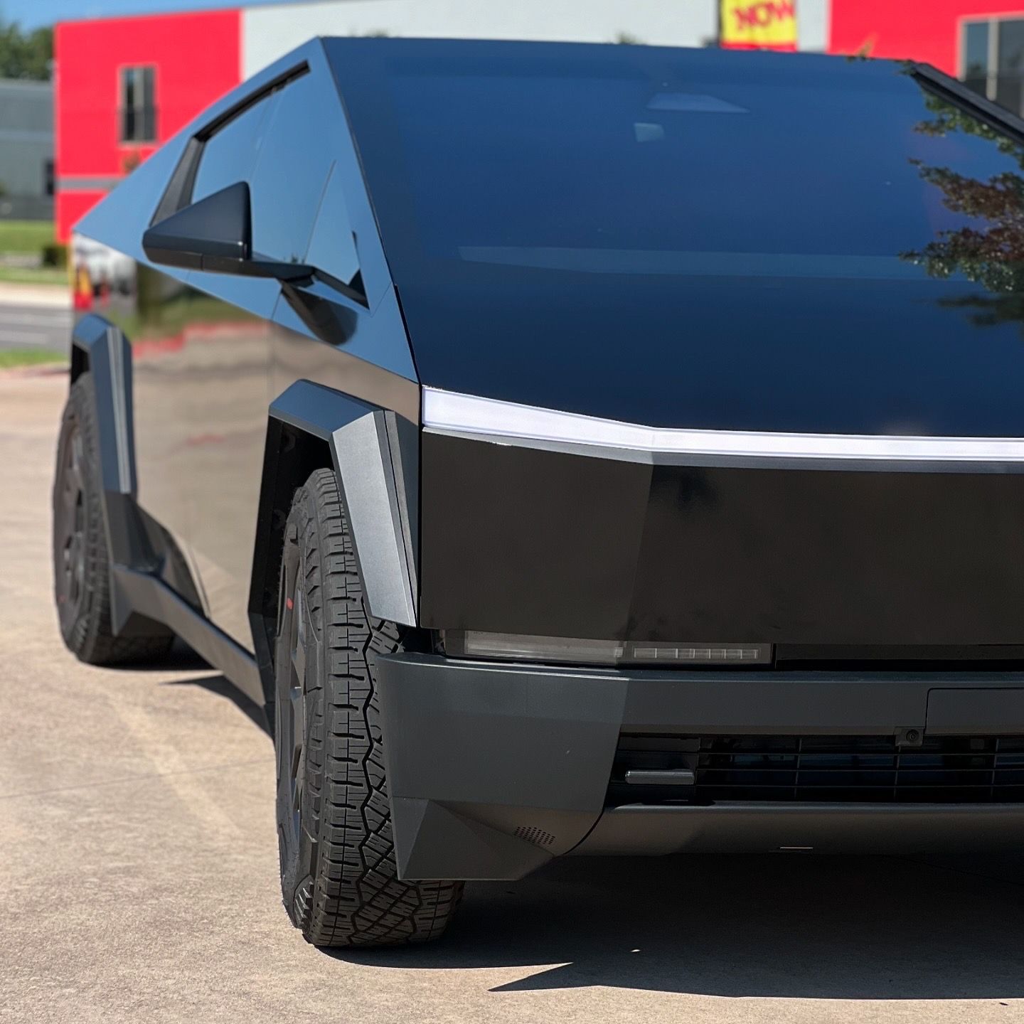 A black car is parked on the side of the road
