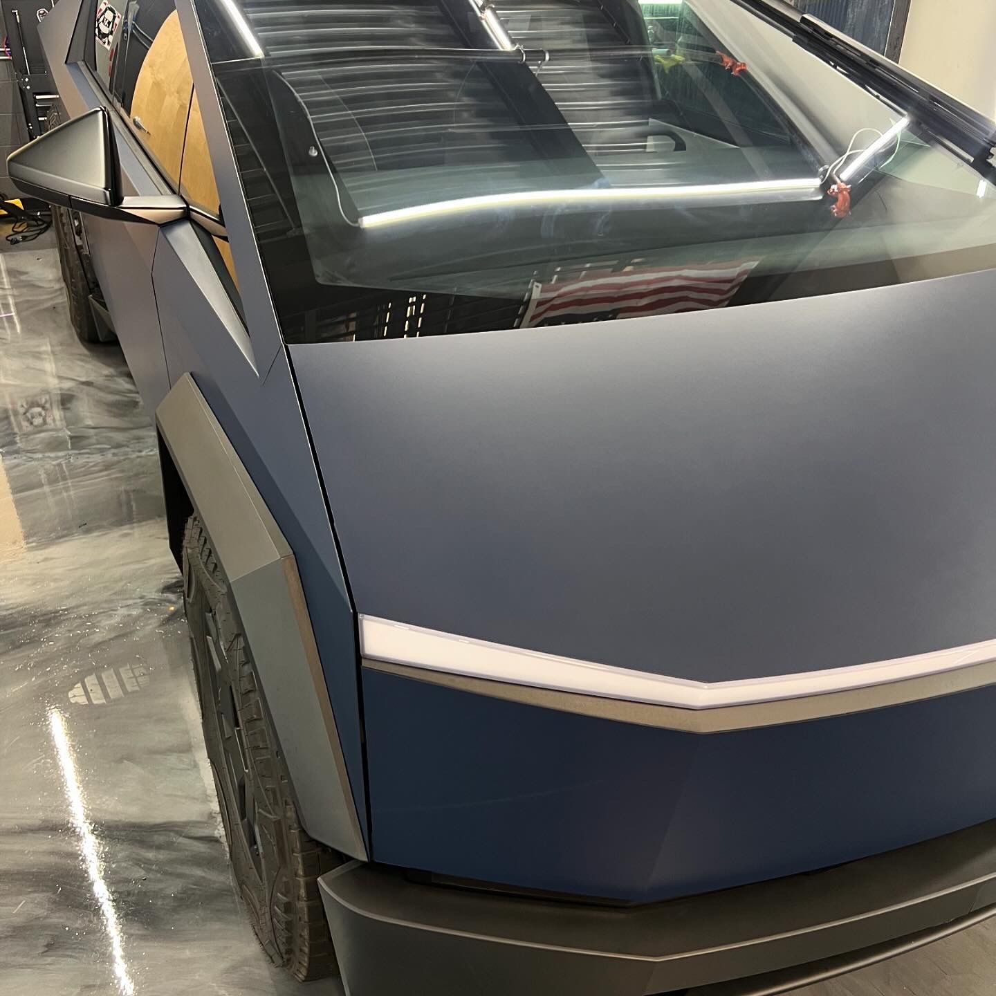 A blue tesla model s is parked in a garage.