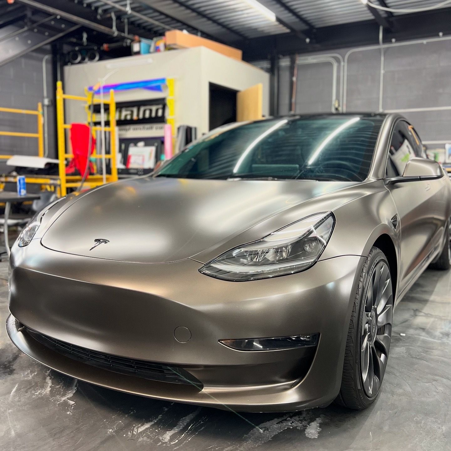 A tesla model 3 is parked in a garage