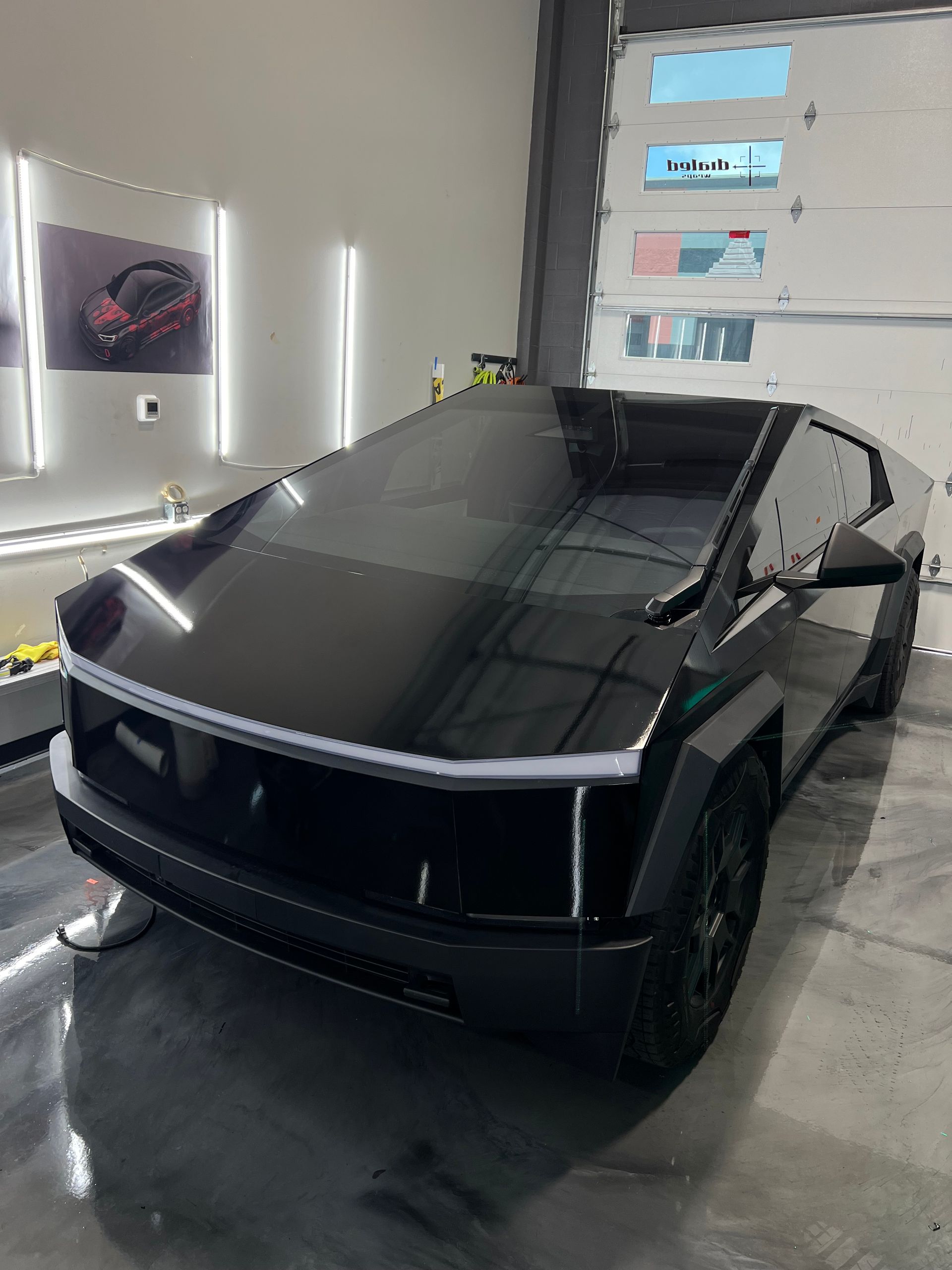 A black tesla model s is parked in a garage.