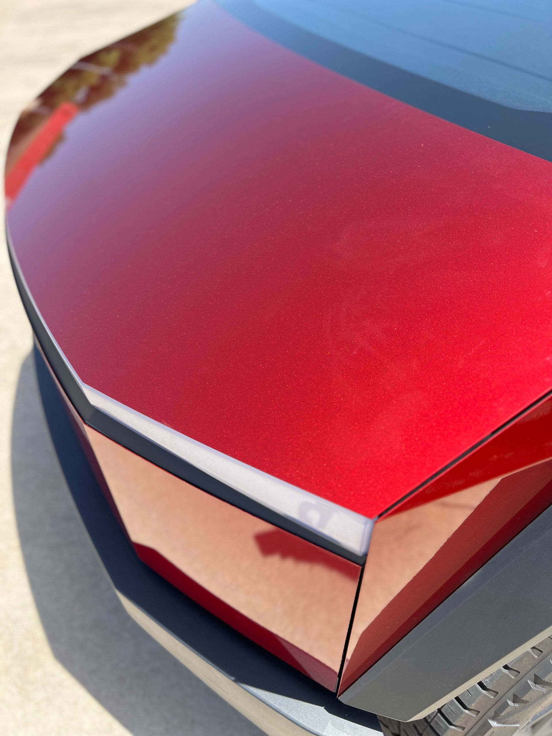A red car is parked on the side of the road
