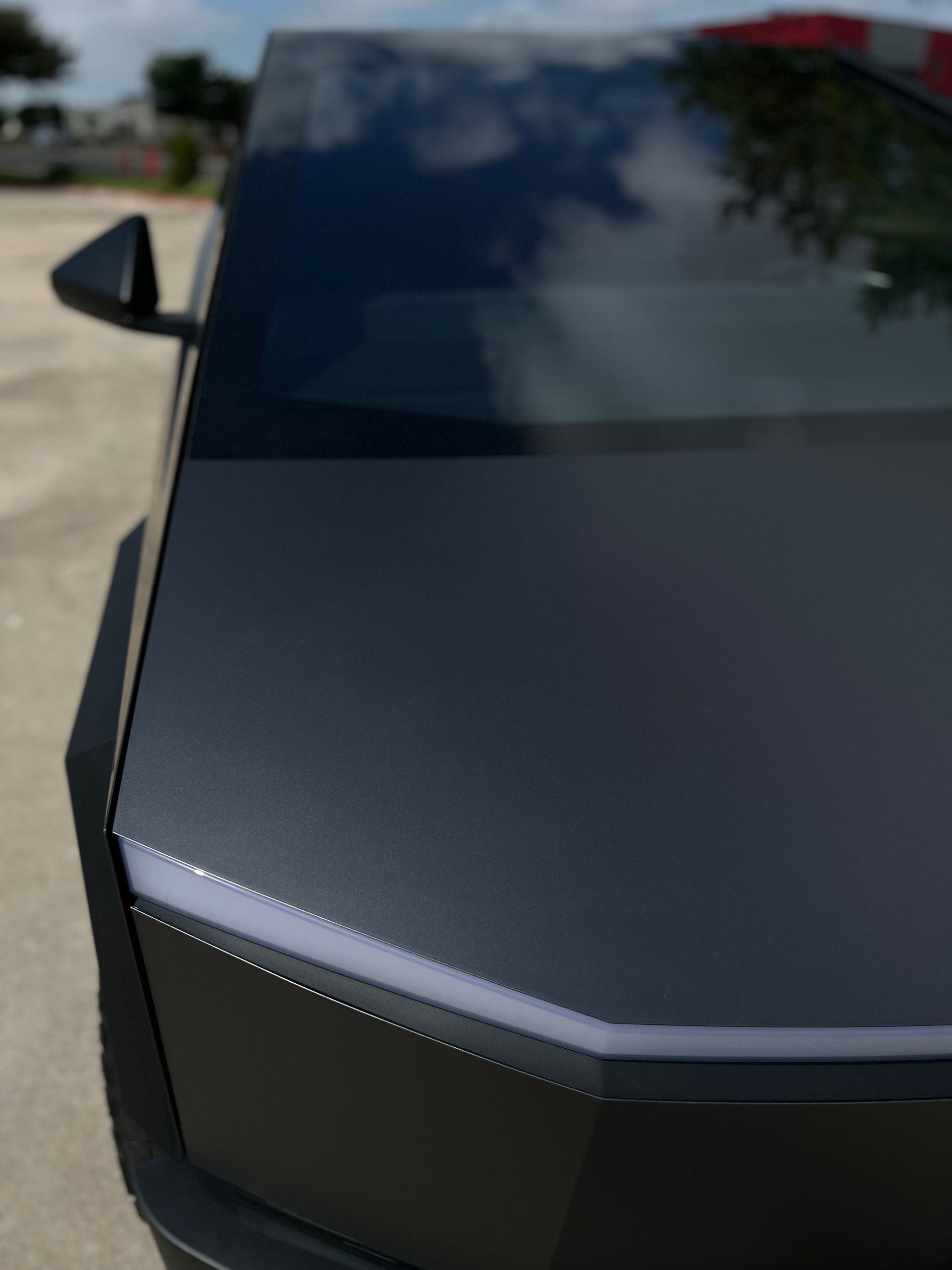 A black sports car is parked in a parking lot