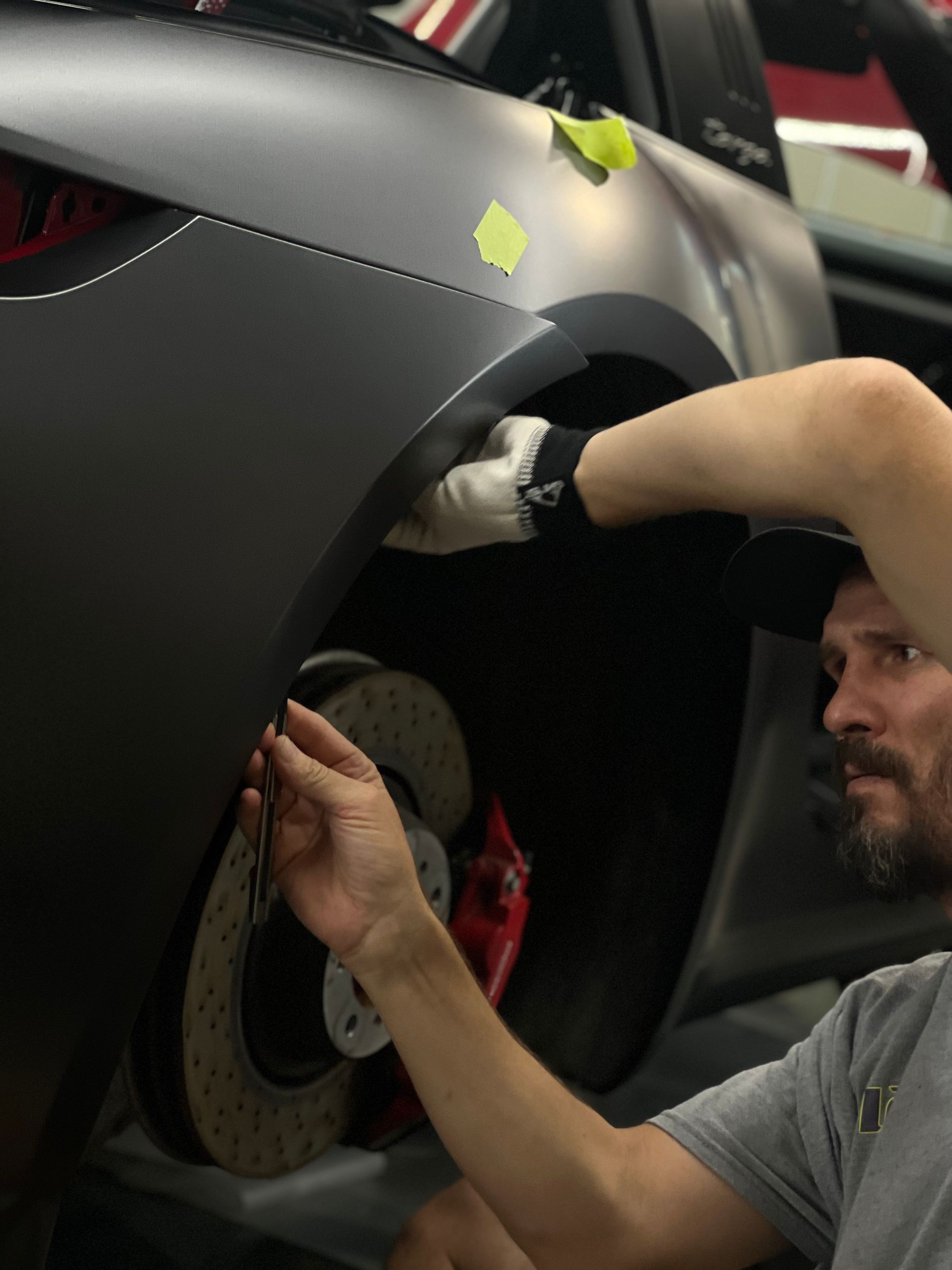 A man is working on the fender of a car