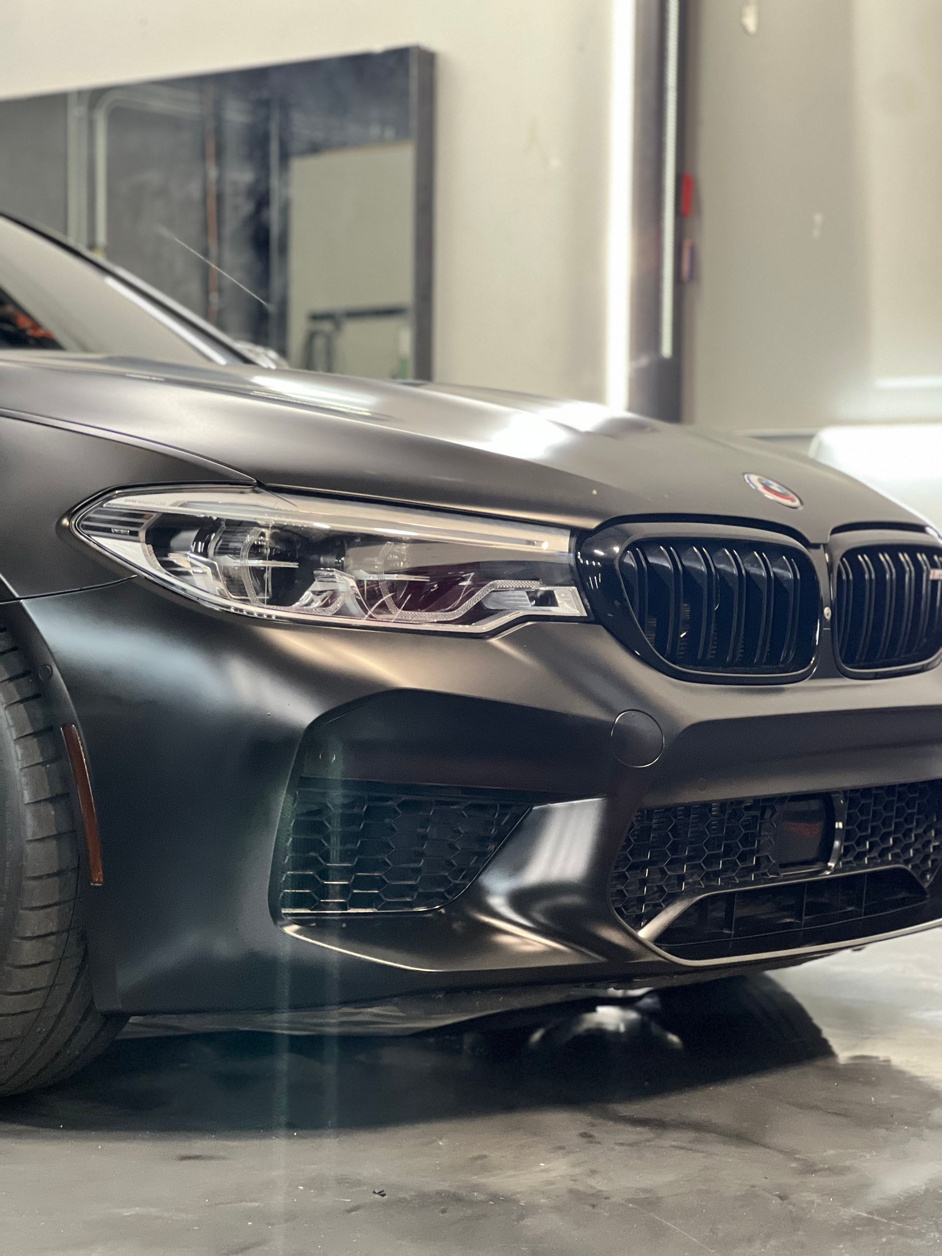 A black bmw m5 is parked in a garage.