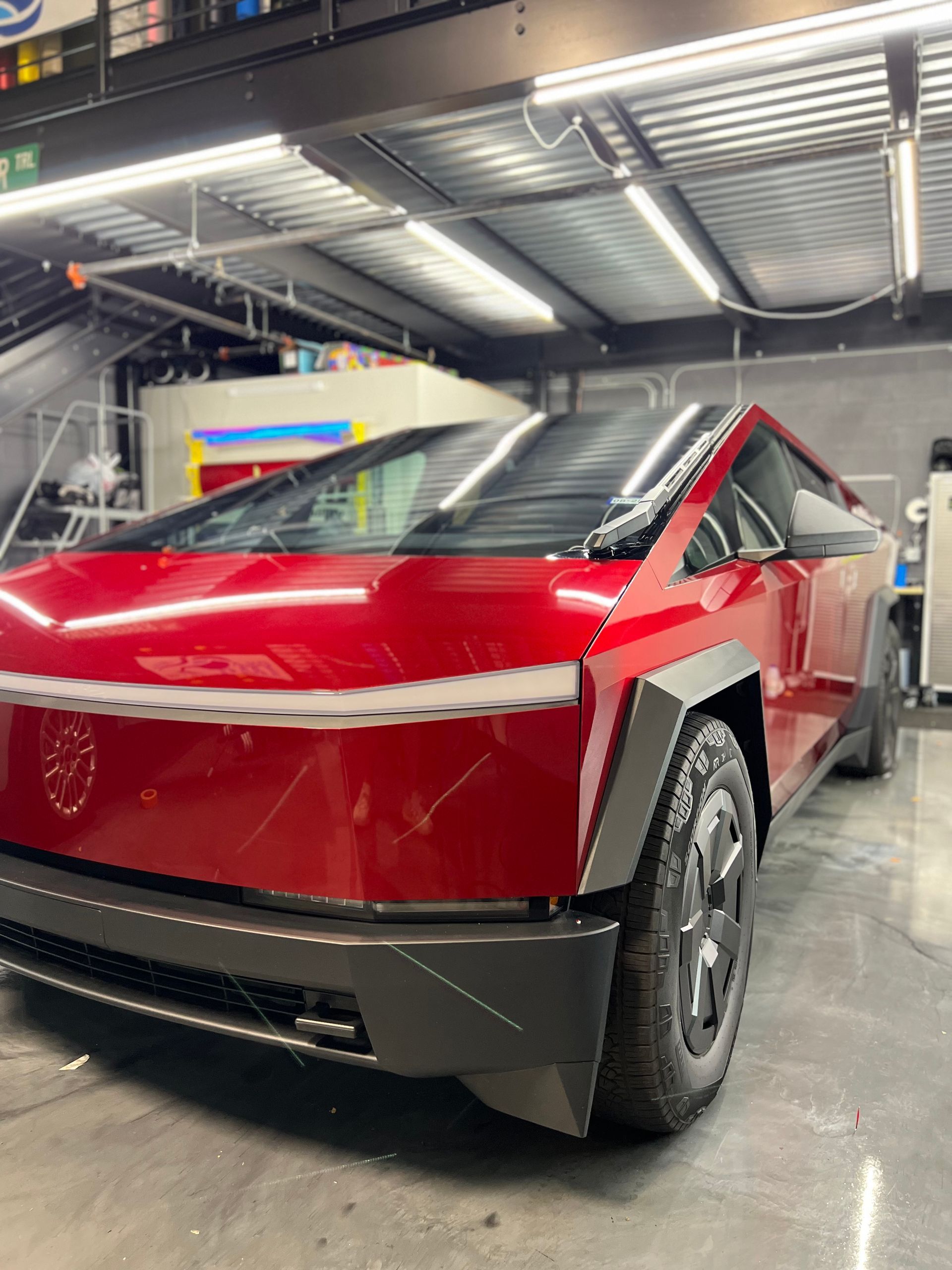A red car is parked in a garage.
