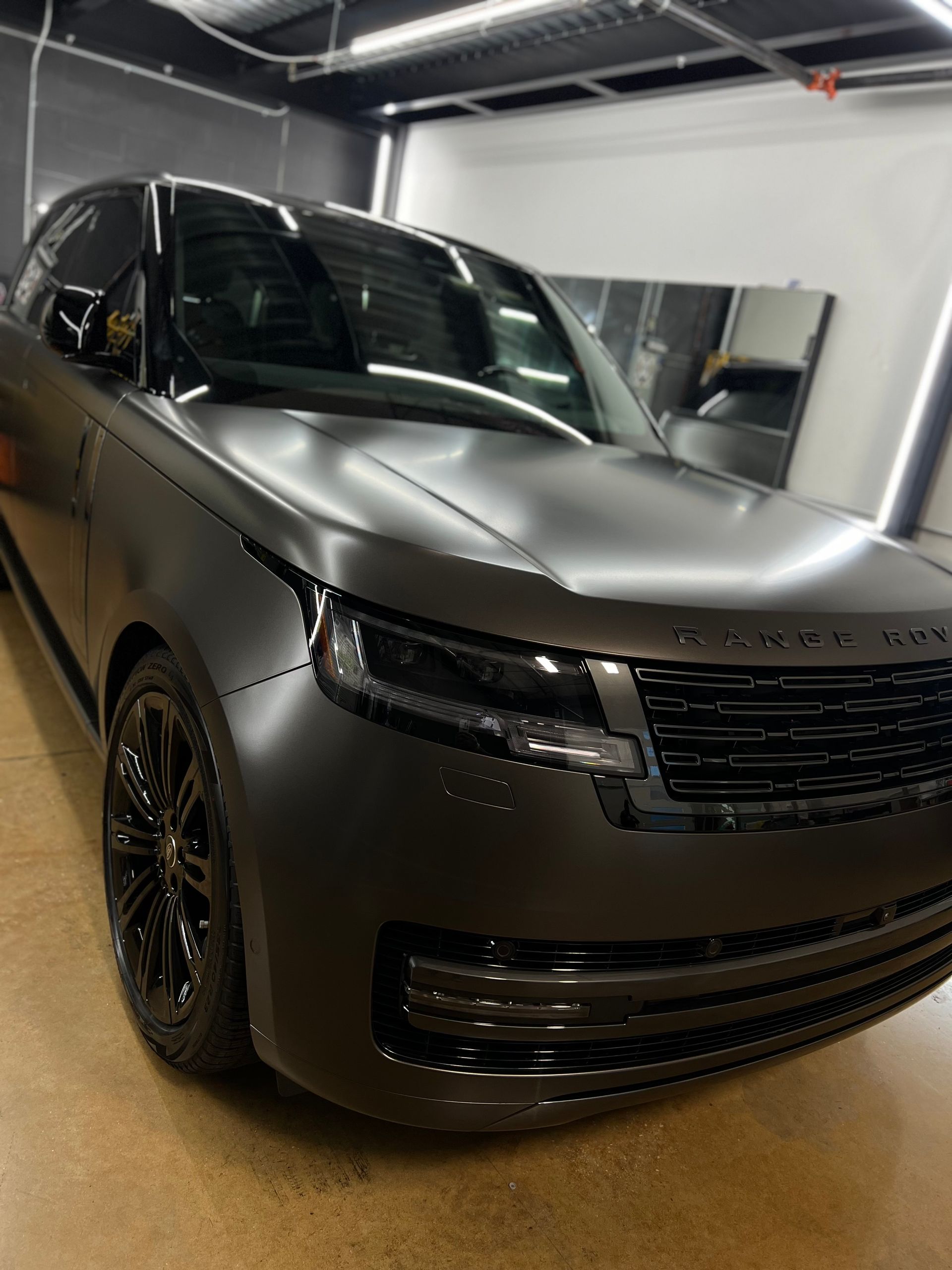 A black range rover is parked in a garage.