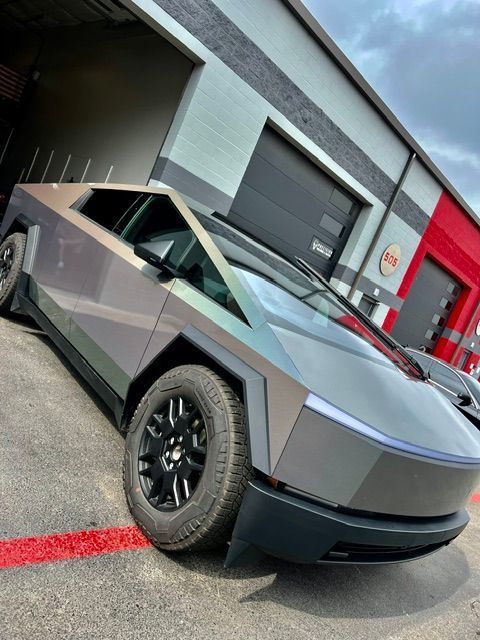 A tesla cybertruck is parked in front of a building