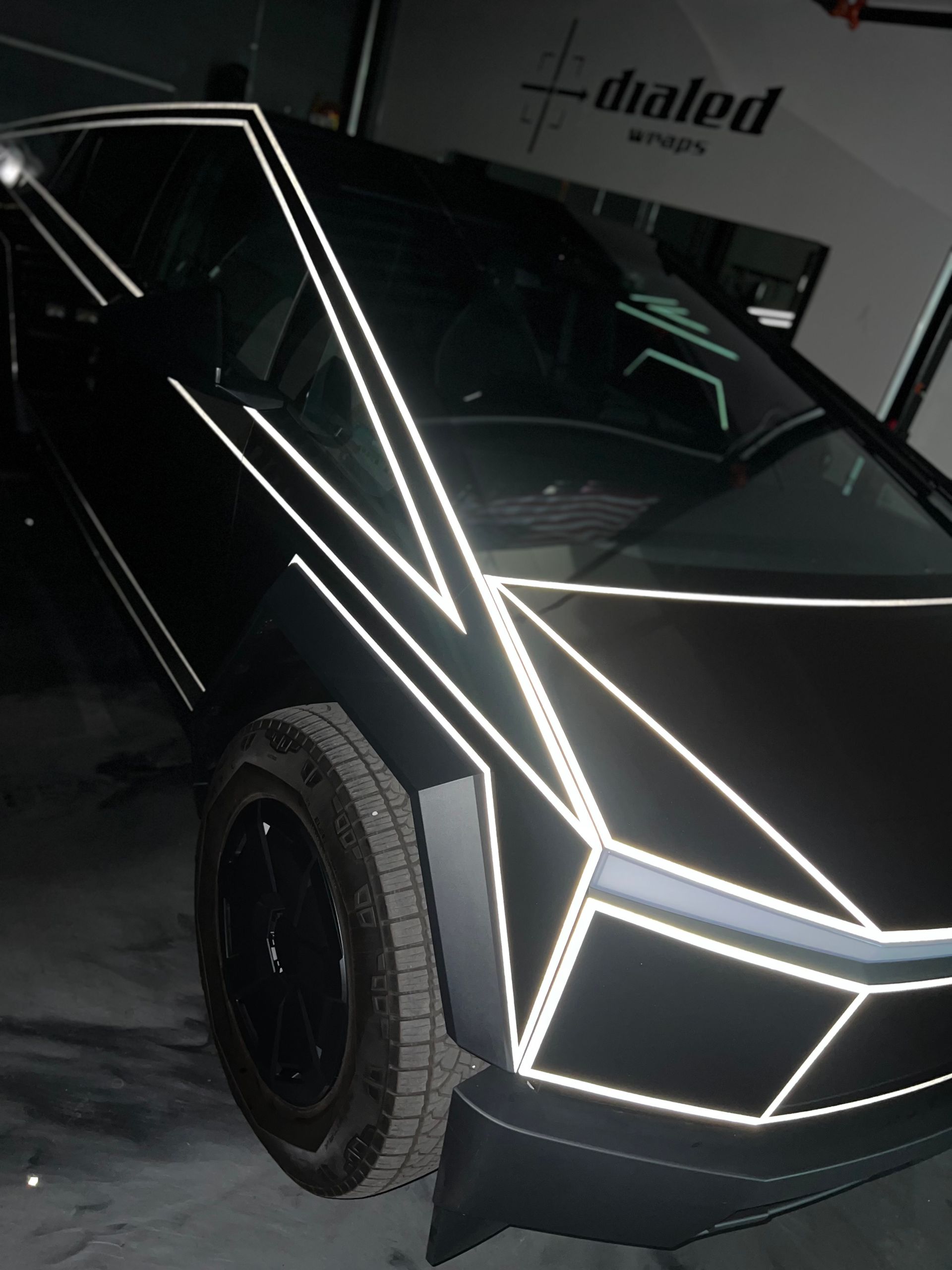 A black cybertruck is parked in front of a building that says dialog