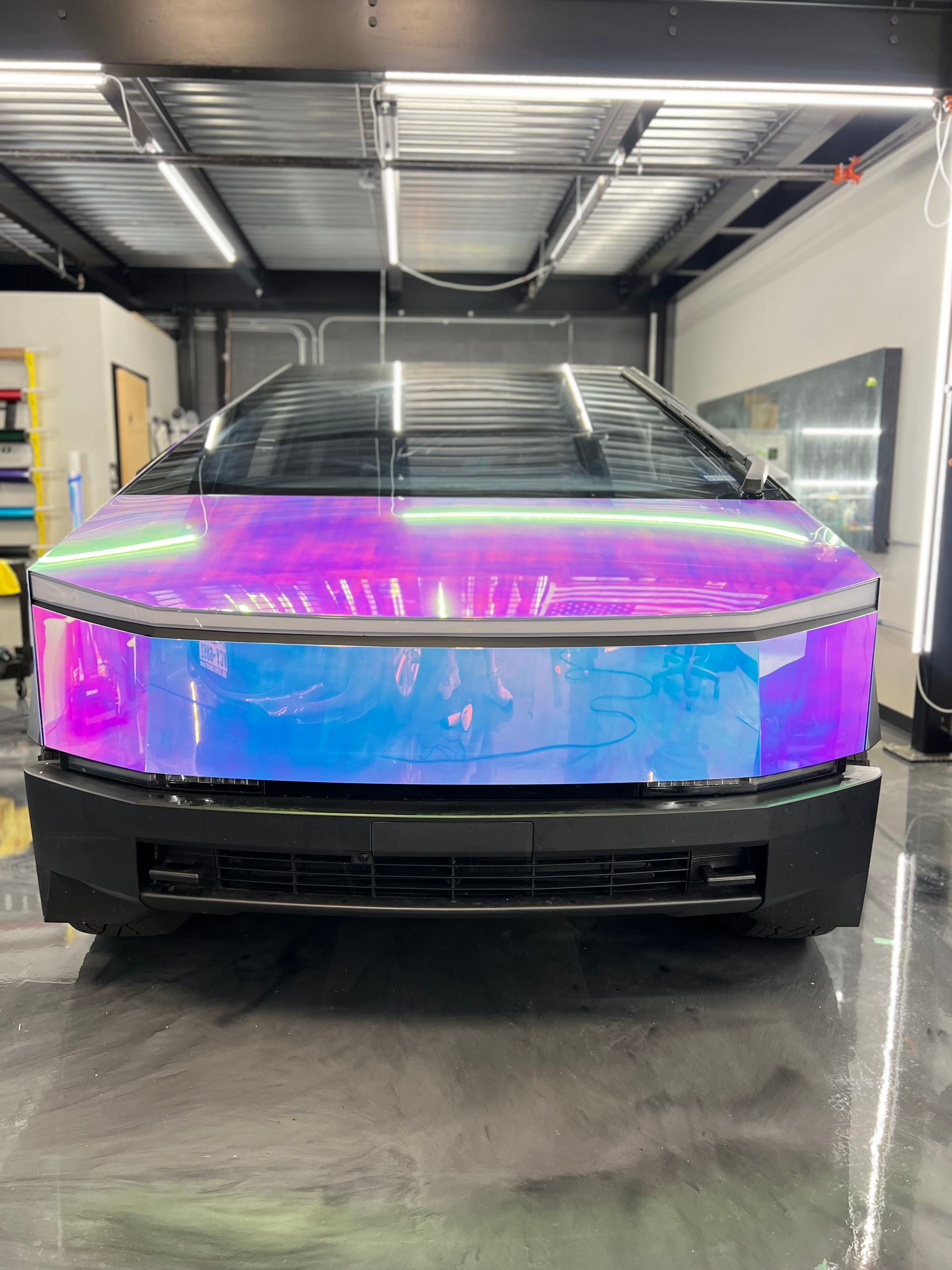 A purple and blue car is parked in a garage.