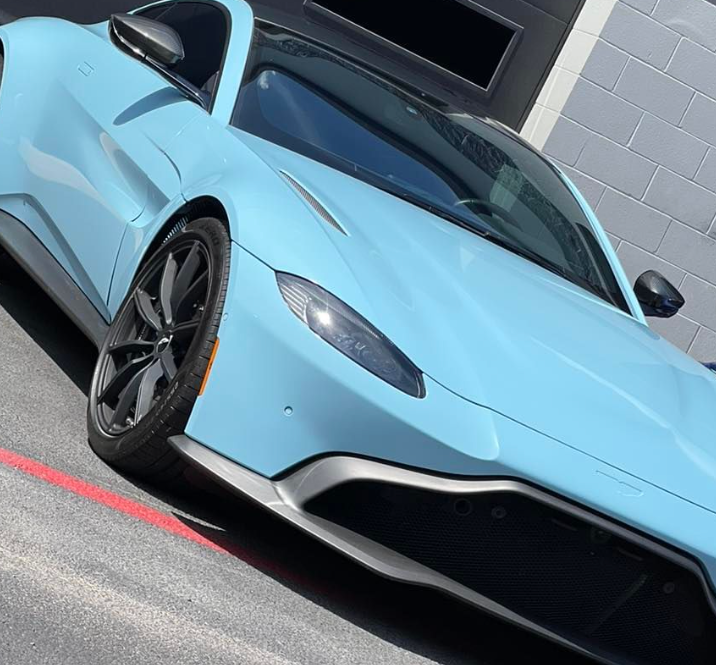 A blue sports car is parked in a parking lot