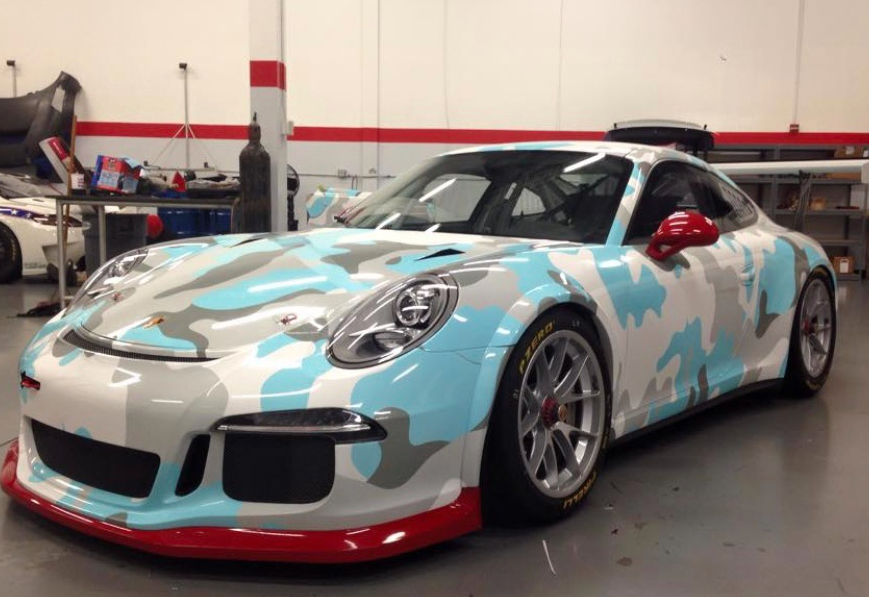 A blue and white sports car is parked in a garage.