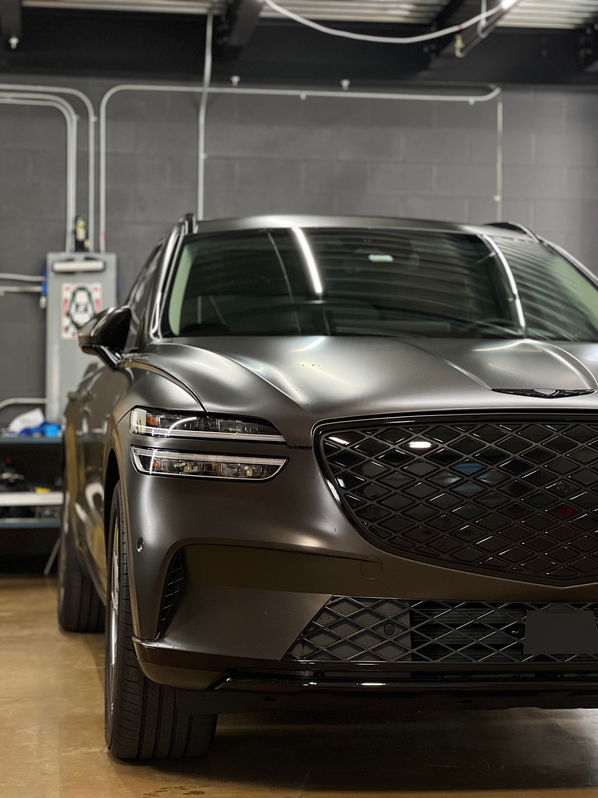 A black car is parked in a garage.