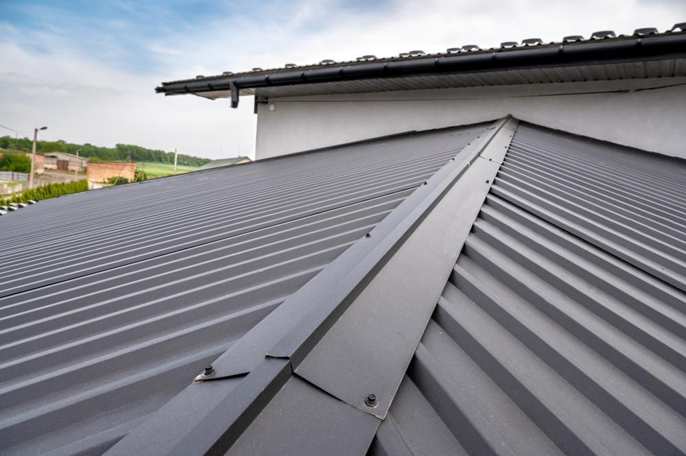 Two Workers Are Working on the Roof of a Building — Stephen Meaker Roofing in Wagga Wagga, NSW