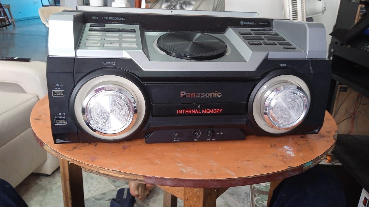 Estéreo Panasonic negro y plateado sobre una mesa de madera.