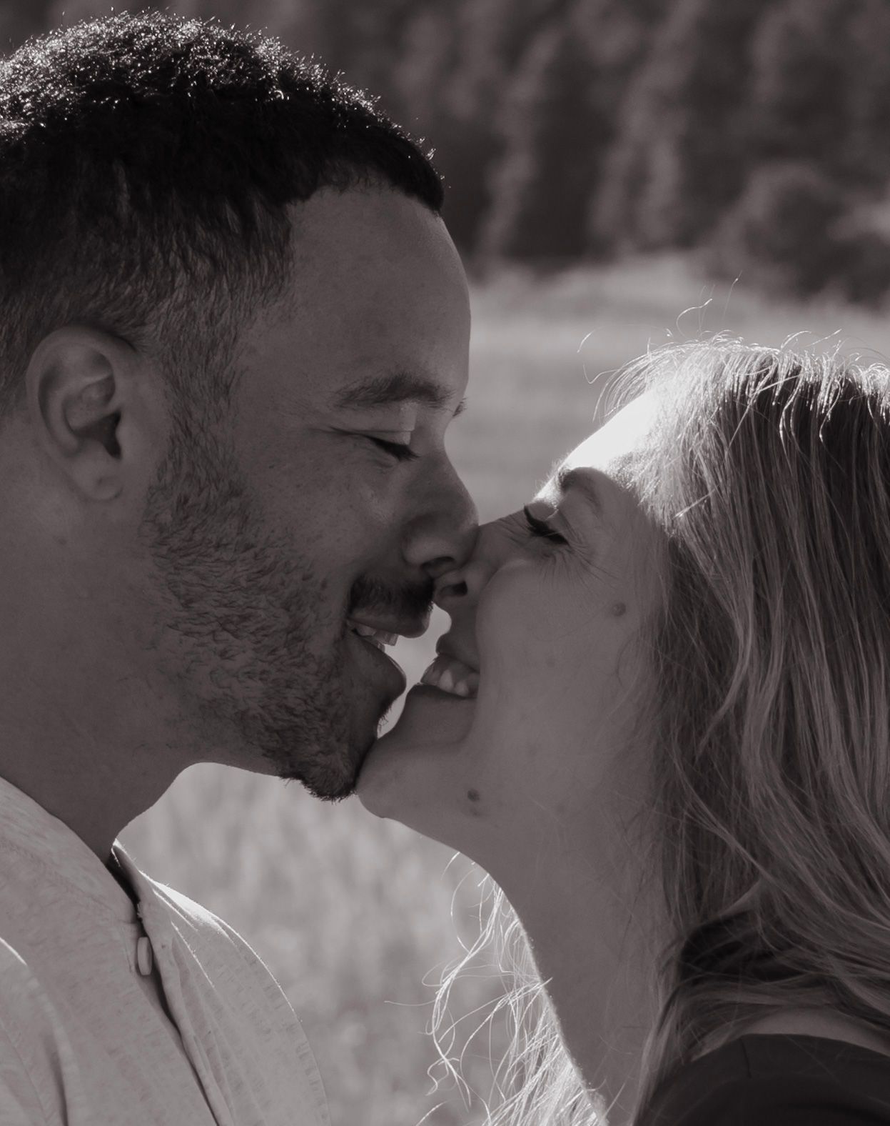 A black and white photo of a man and woman kissing