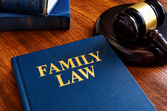 Blue “Family Law” book beside a gavel on a wooden desk