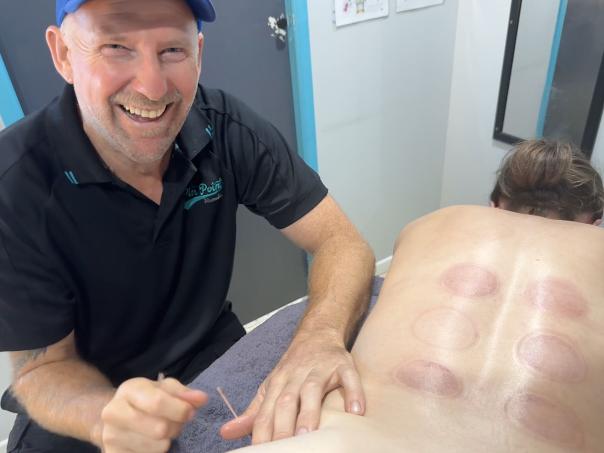 A Woman Is Helping Another Woman Do Yoga On A Mat — Pin Point Remedial Massage In Lammermoor, QLD
