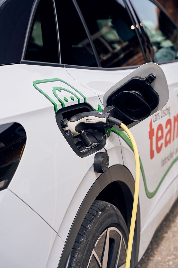 Ein weißes Auto mit dem Wort „Team“ auf der Seite wird aufgeladen