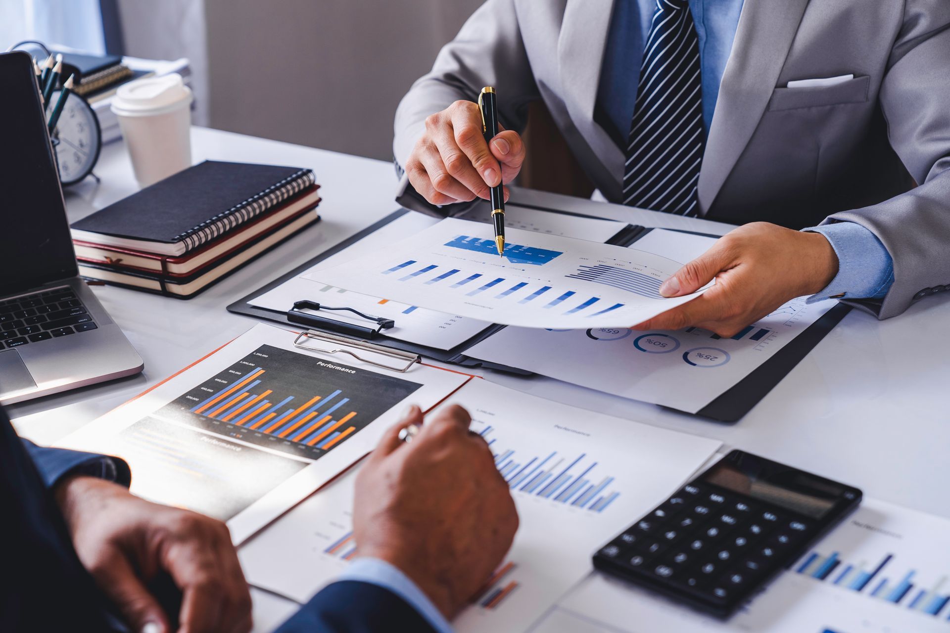 Business people reviewing charts and graphs at a desk during a meeting