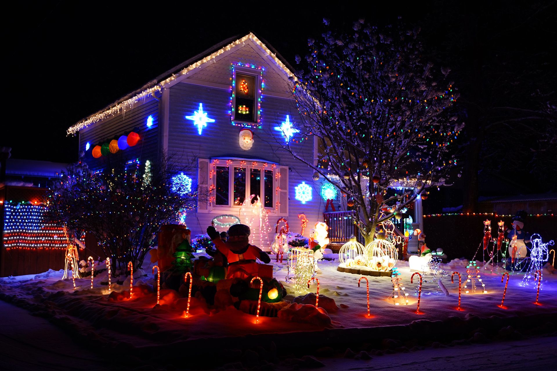 House decorated with white Christmas lights on brick exterior.