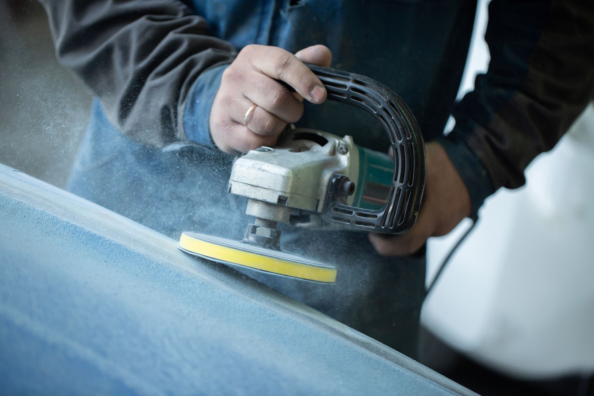 Auto body shop technician sanding vehicle surface during repair preparation. Auto body shop technician sanding vehicle surface during repair preparation.