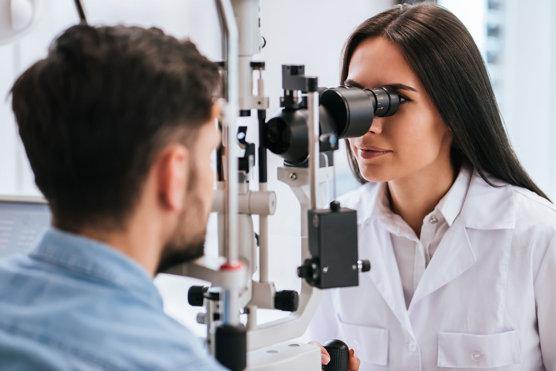 A doctor is checking a patient’s eyes.