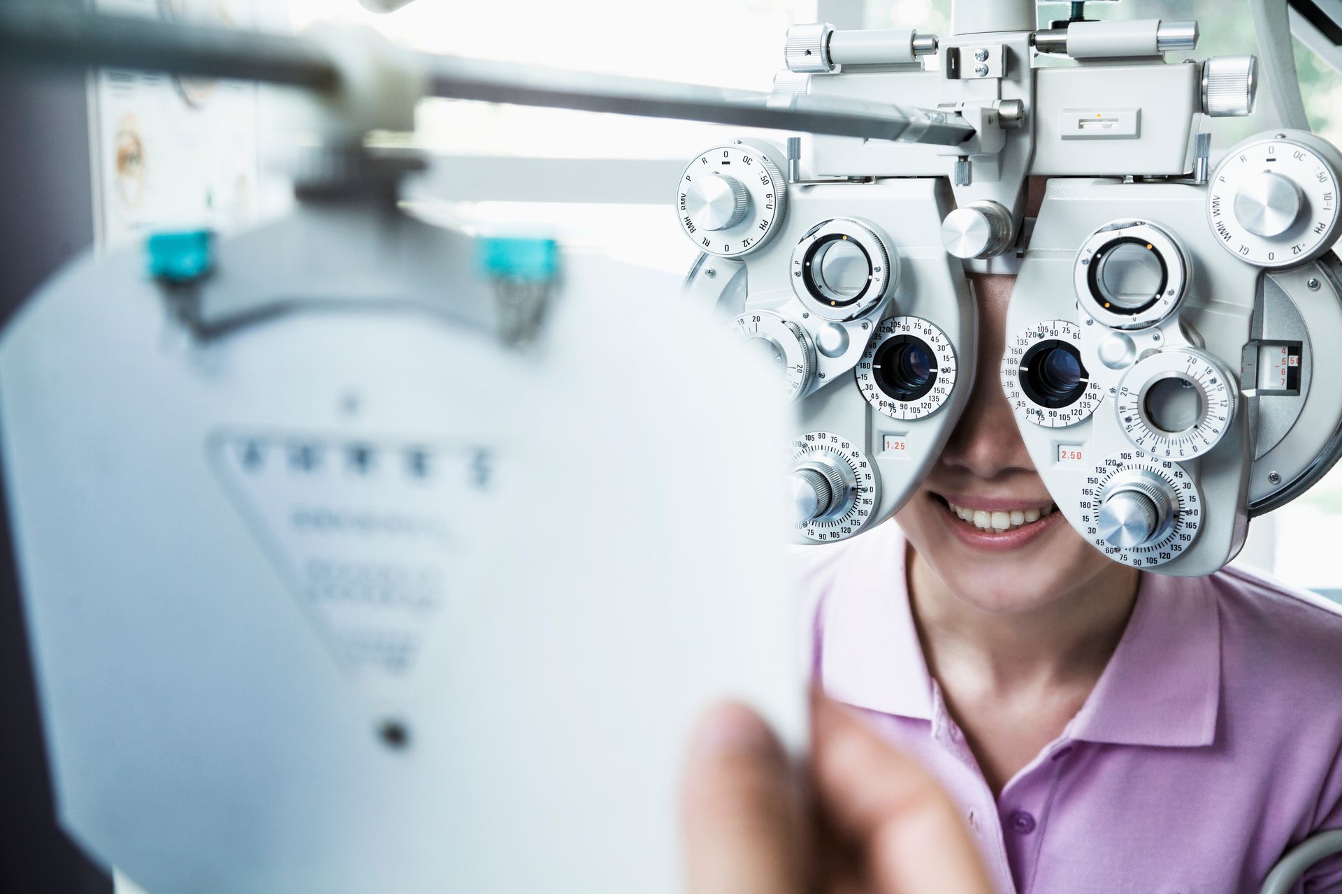 Patient testing vision with an eye exam phoropter, highlighting professional optometrist services. Patient testing vision with an eye exam phoropter, highlighting professional optometrist services.