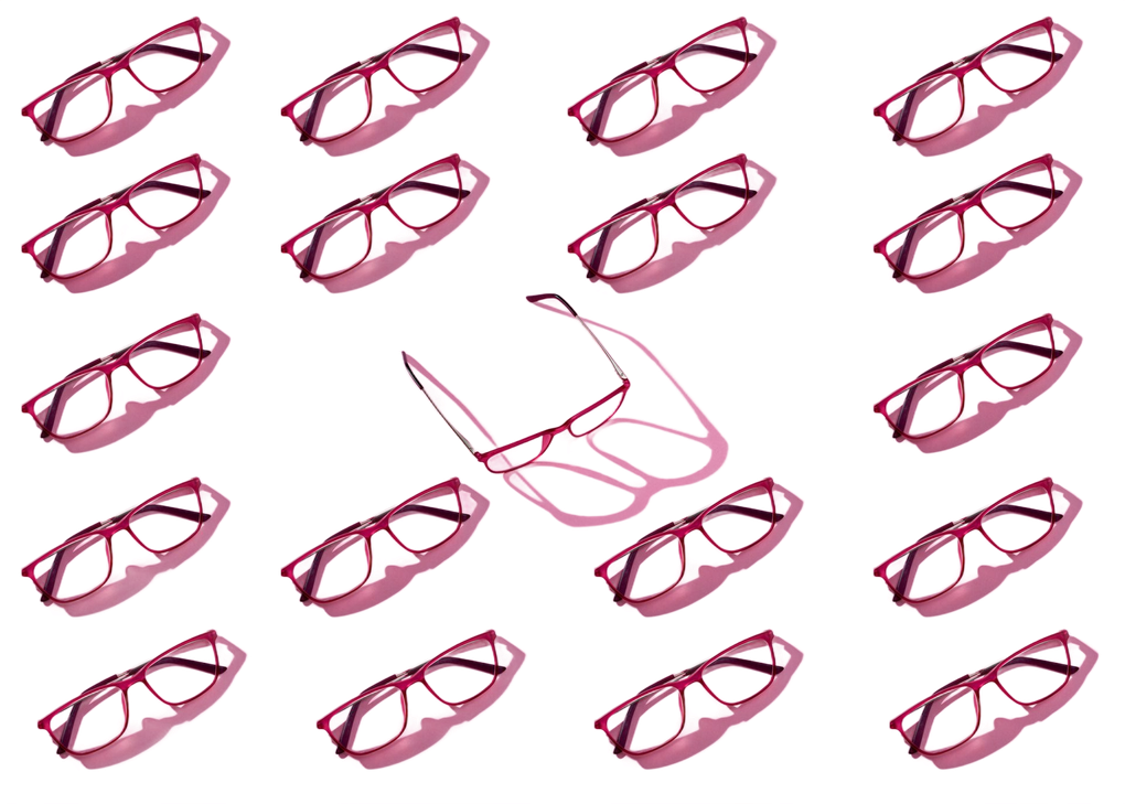 Rows of pink-framed eyeglasses, one pair upright, casting a shadow on a white background. Rows of pink-framed eyeglasses, one pair upright, casting a shadow on a white background.