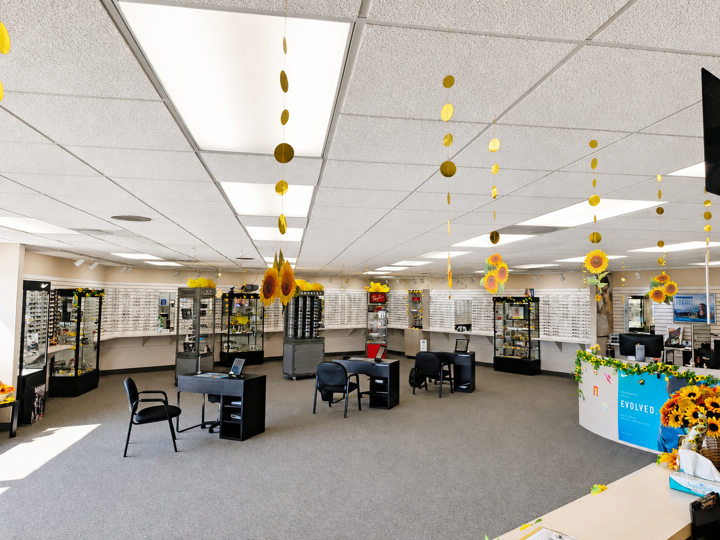 Office lobby with desks, chairs, and shelves under fluorescent ceiling lights