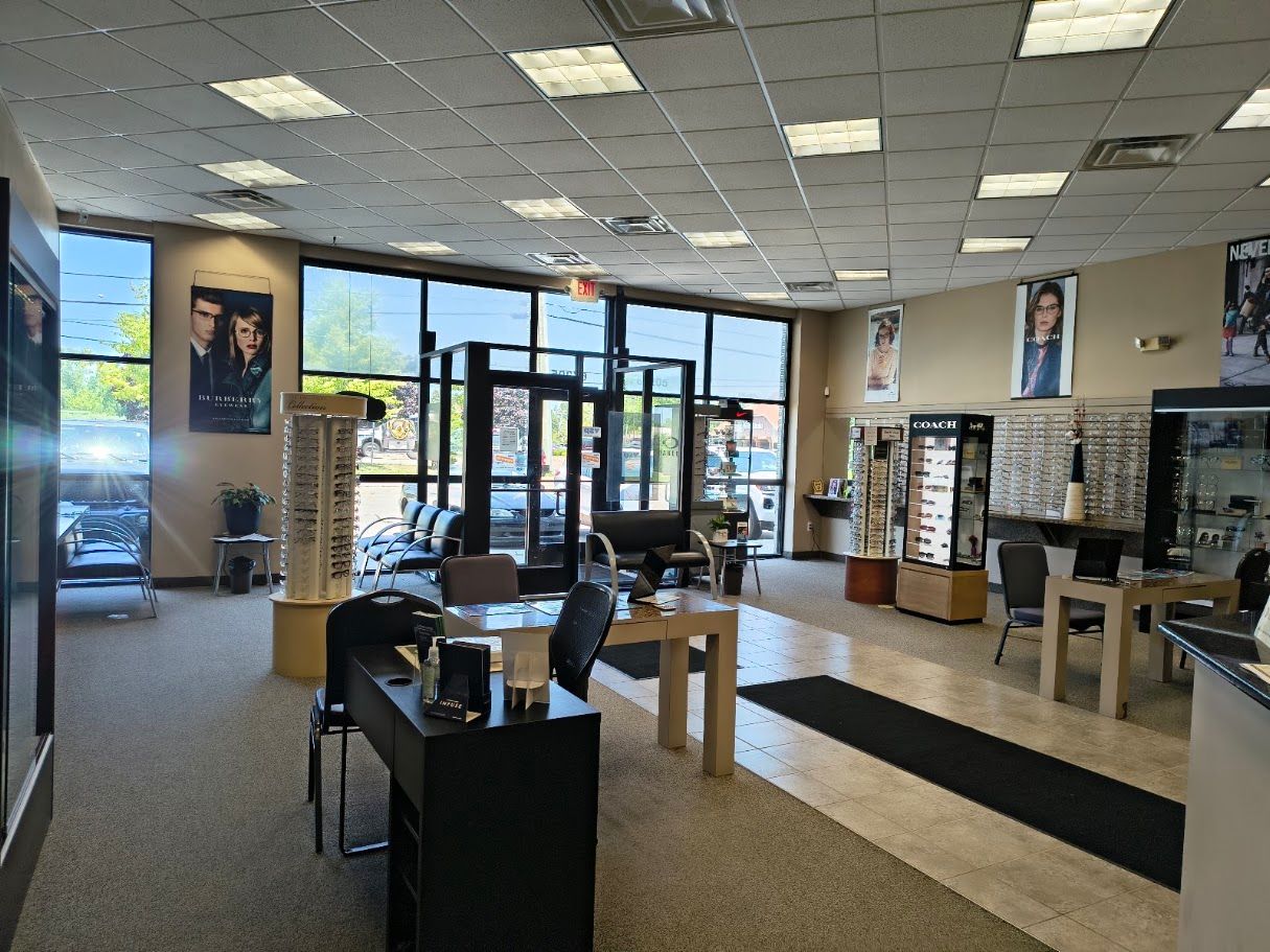 Interior of an optometrist's office with eyeglass displays, a front desk, and a waiting area.