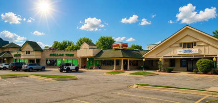 Fraser Optical storefront with a green roof, tan facade, and sign with red and yellow lettering. Fraser Optical storefront with a green roof, tan facade, and sign with red and yellow lettering.