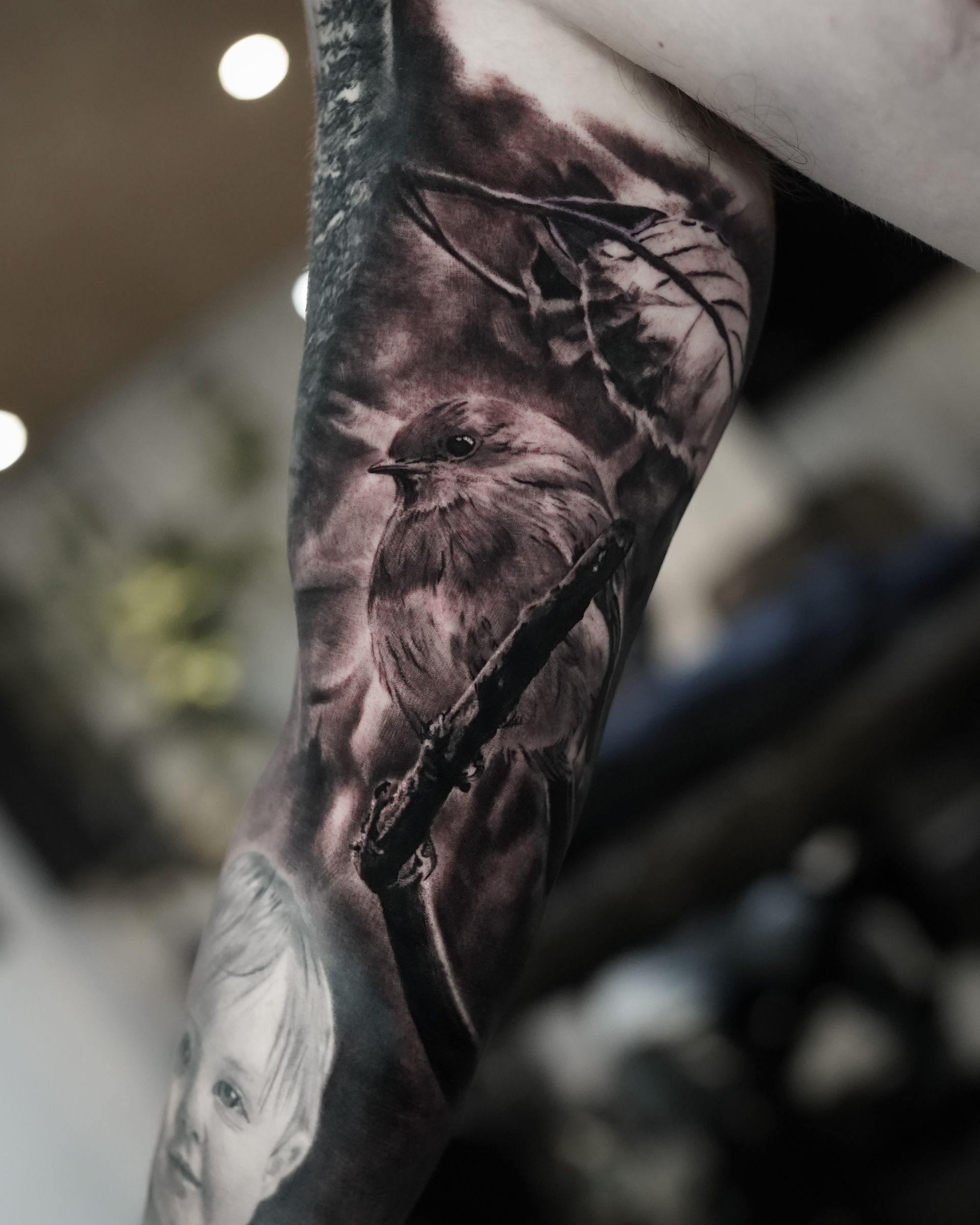A person has a tattoo of a bird on their arm