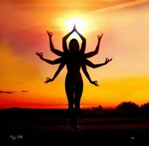 Silhouette of a multi-armed dancer posing against a glowing orange sunset sky