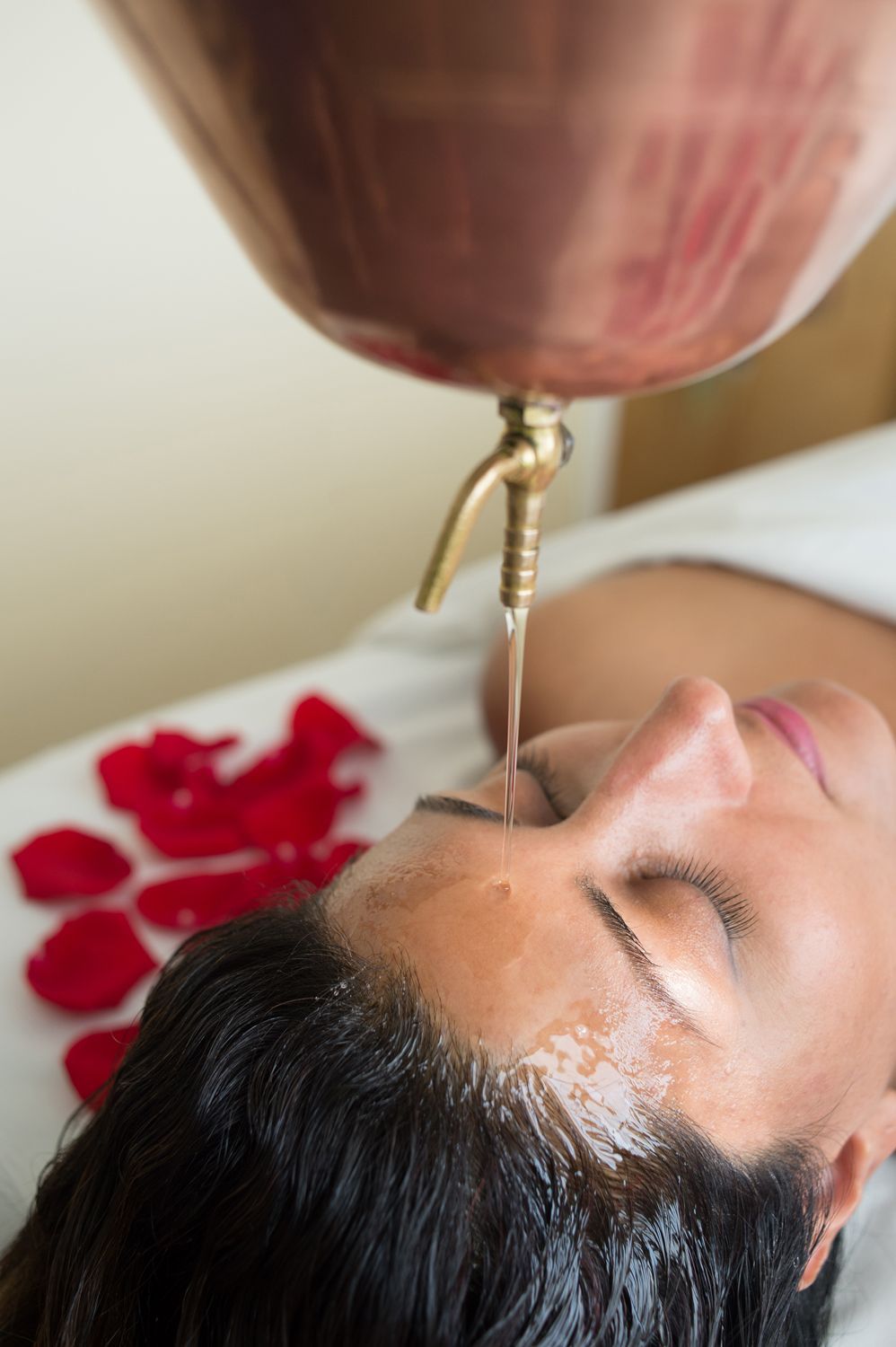 Close-up of a back massage with hands pressing on the skin in a warm, spa-like setting