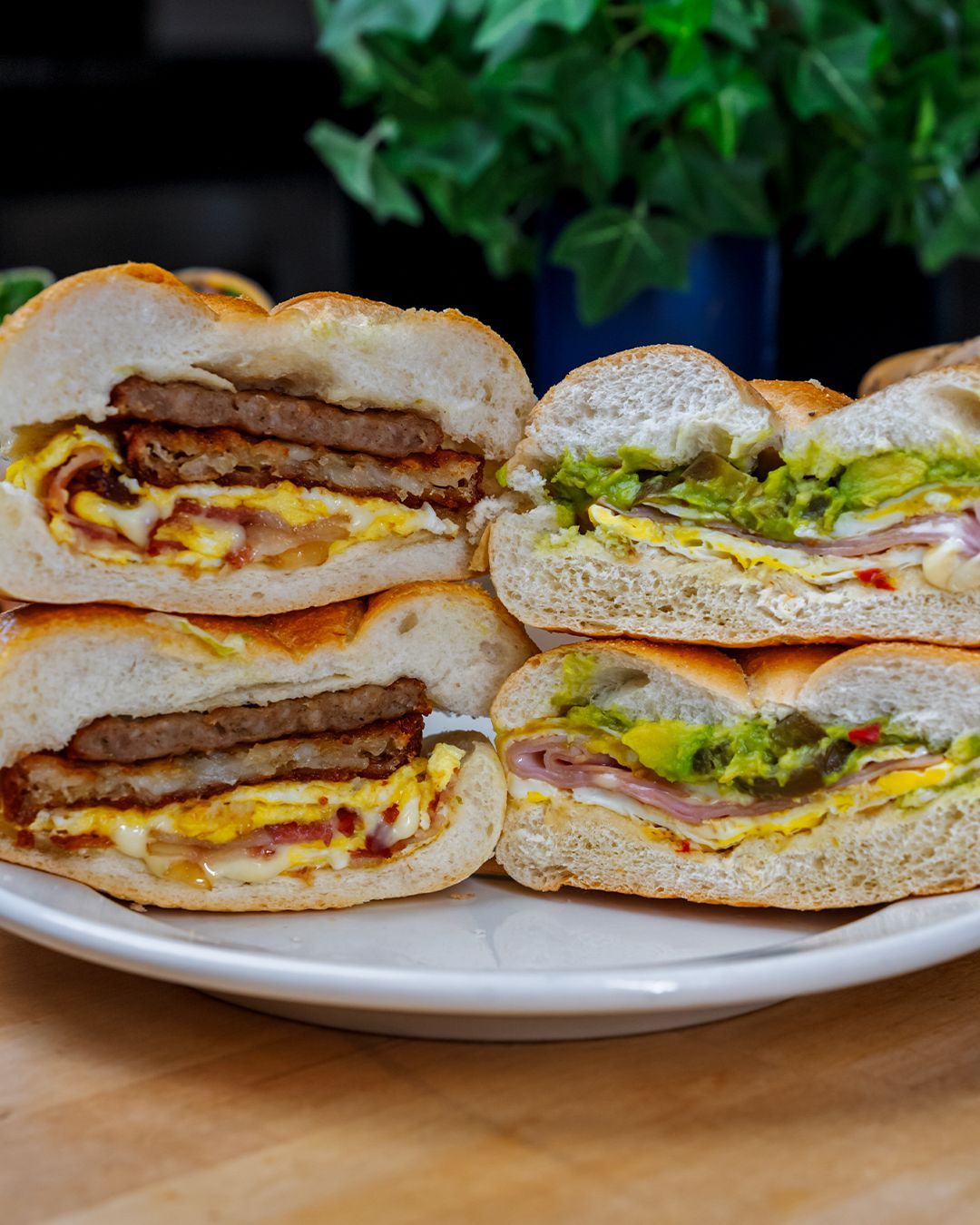 Three sandwiches are stacked on top of each other on a white plate.